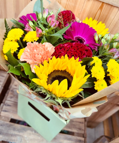 Summer Celebration - A vibrant hand-tied bouquet bursting with bold colour, joyful energy, and fresh seasonal charm. Featuring a lively mix of bright tones, textured blooms, and lush greenery, this arrangement is beautifully wrapped for a modern rustic look. Perfect for birthdays, congratulations, thank-you gifts, or simply bringing warmth and happiness to any occasion.